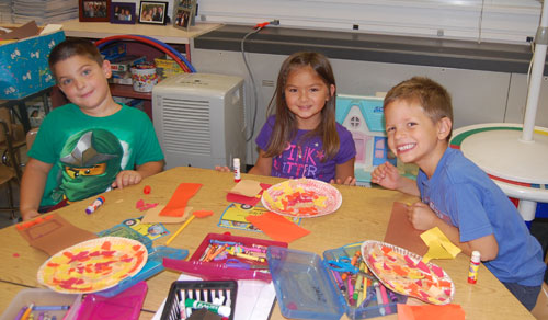Kindergartners making paper plate trees and leaves for Autumn 